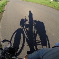 The shadow of a touring cyclist.