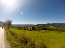 Cycling towards Sarajevo with snowcapped peaks in the background.
